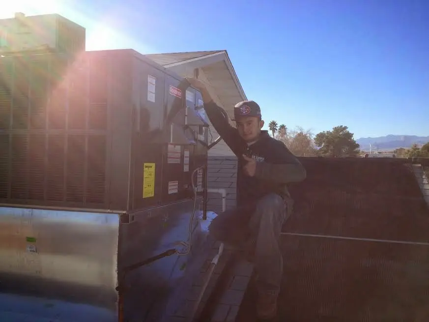 HVAC technician performing AC Tune-Up on a rooftop unit in Big Spring